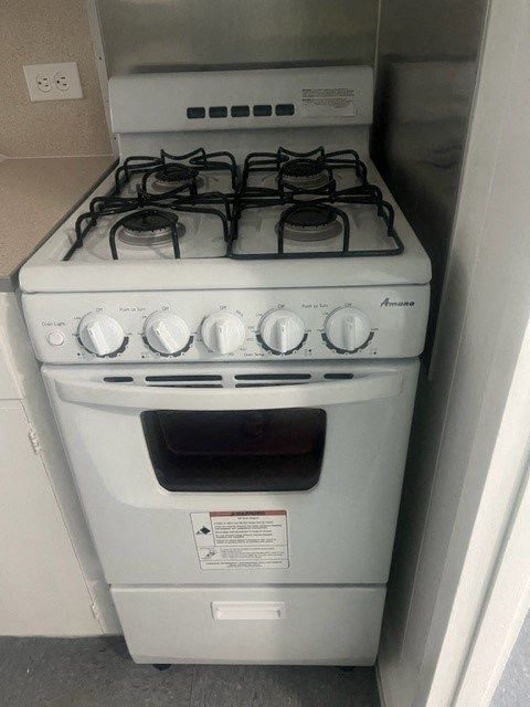 a white stove top oven sitting inside of a kitchen